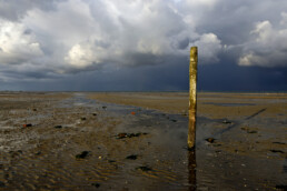 Donkere, dreigende wolkenlucht van hagelbui boven de Waddenzee bij vogelreservaat De Volharding op Waddeneiland Texel
